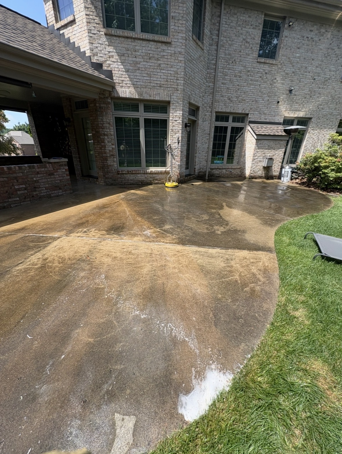 Stained, grime-covered concrete patio on a South Hills home before pressure washing.