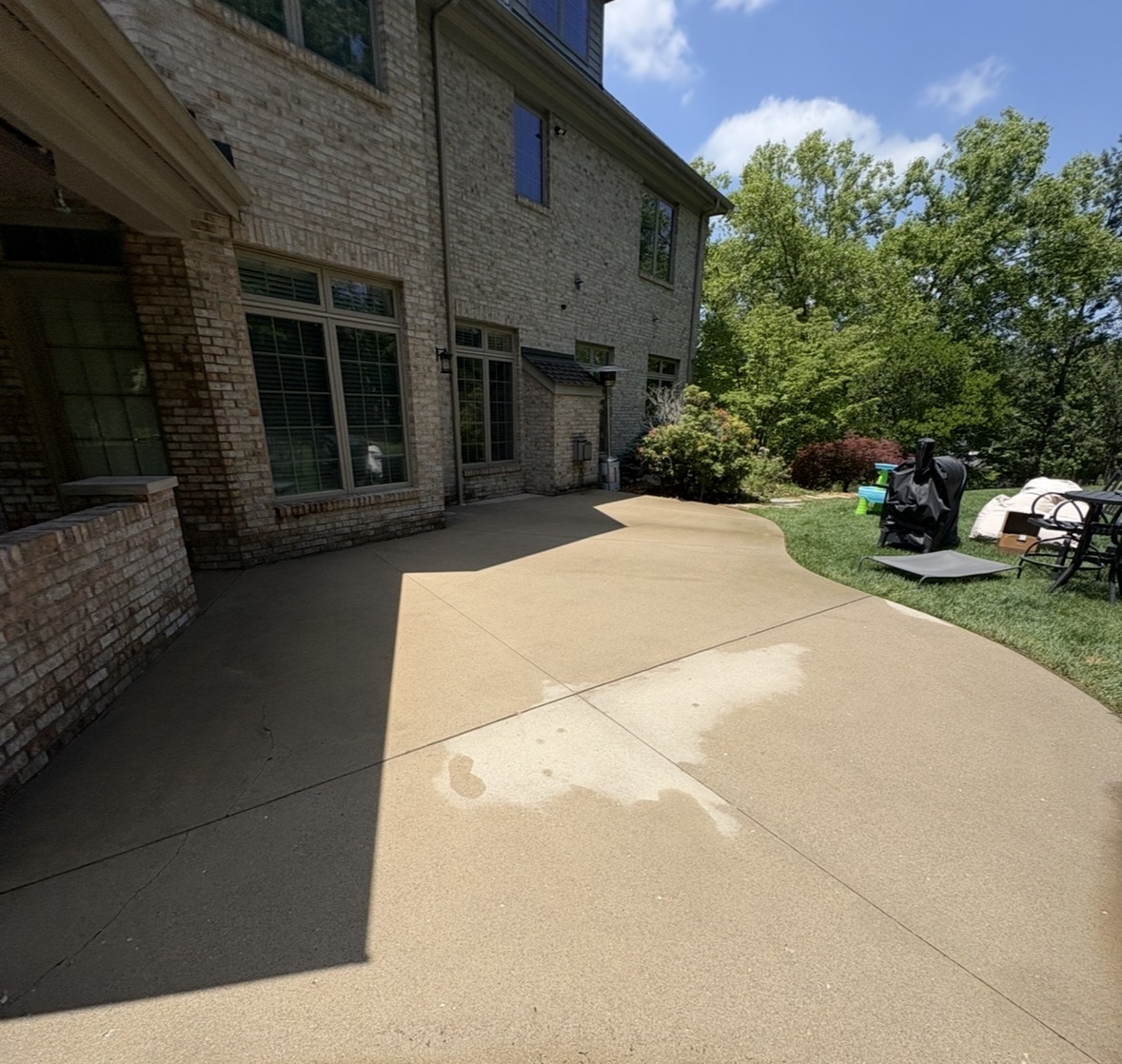 Same patio after, with years of dirt lifted and concrete restored to a bright, even finish.
